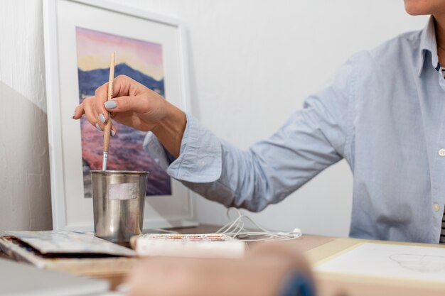 Front view of woman holding paint brush