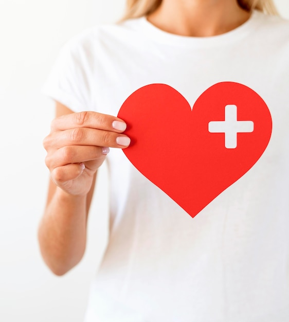 Free photo front view of woman holding paper heart