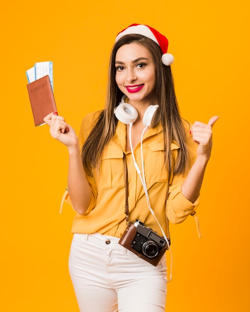 Free photo front view of woman holding passport with plane tickets and giving thumbs up