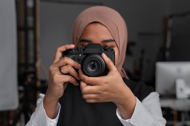 Front view woman holding photo camera