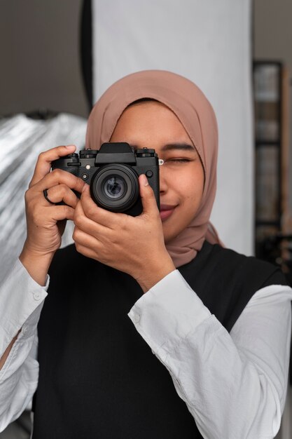 Front view woman holding photo camera