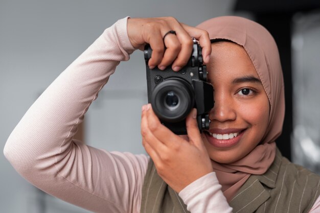 Front view woman holding photo camera