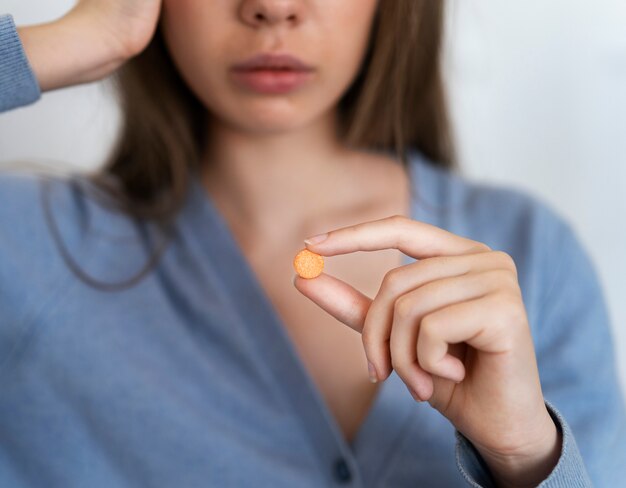 Front view woman holding pill
