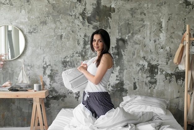 Free photo front view woman holding pillow