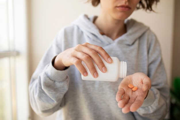 Front view woman holding pills