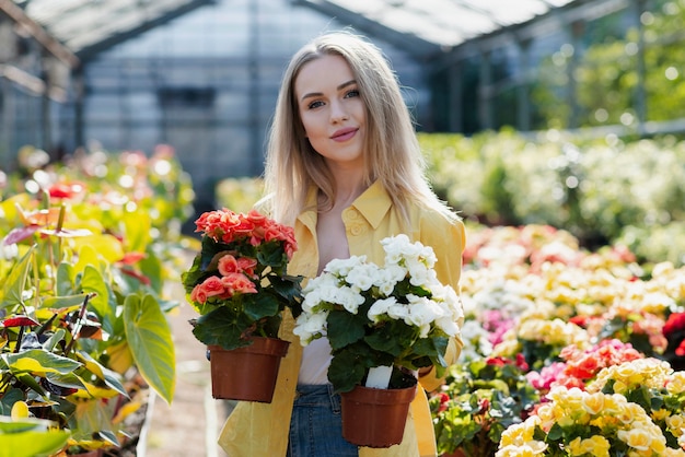 Front view woman holding pots with flowers