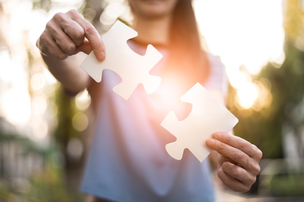 Front view of woman holding puzzle pieces