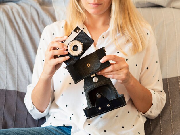 Front view woman holding a retro photo camera