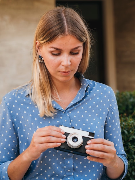 Front view woman holding a retro photo camera