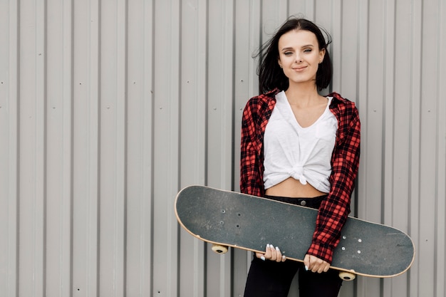 Front view of woman holding skateboard