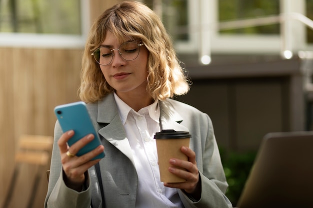 Free photo front view woman holding smartphone