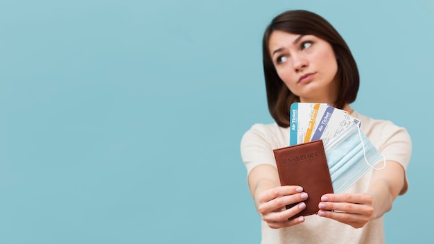 Front view woman holding some airplane tickets with copy space