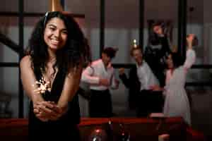 Free photo front view woman holding sparklers at new year's eve party with copy space