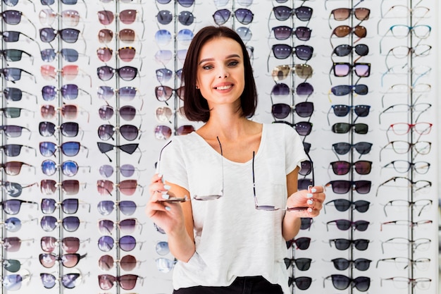 Front view of woman holding sunglasses pairs