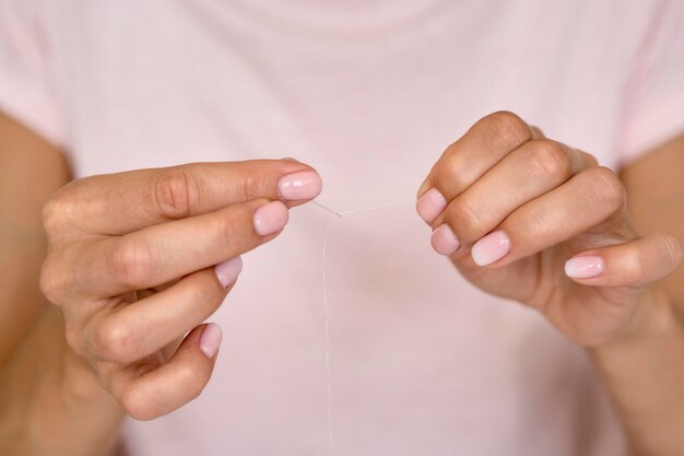 糸と針を保持している女性の正面図