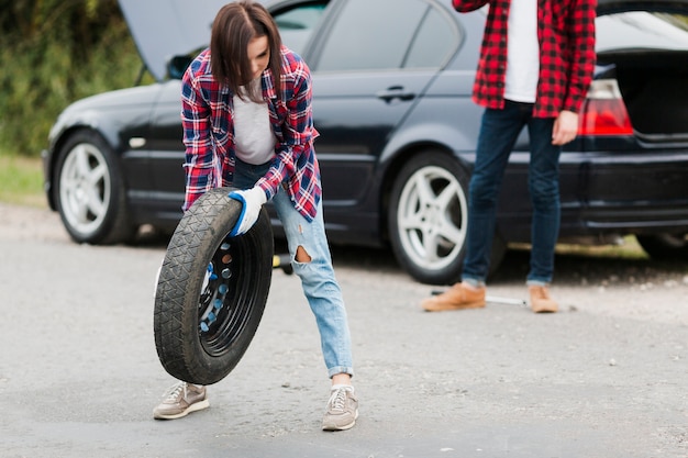 Free photo front view of woman holding tire