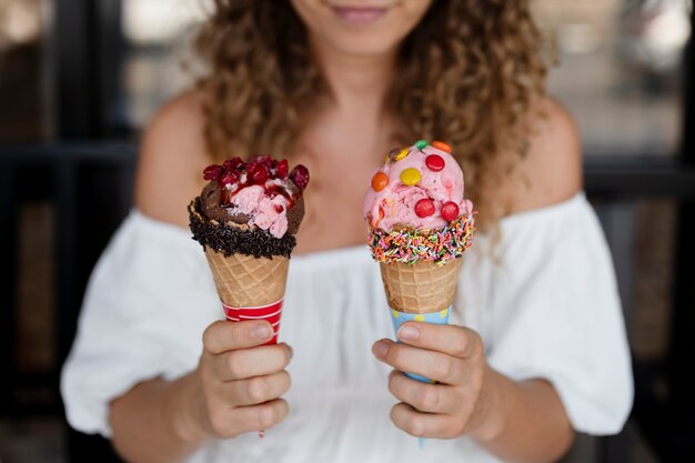 Женщина вид спереди держит два мороженого
