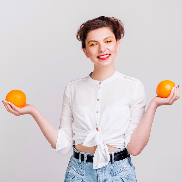 Free photo front view of woman holding two oranges