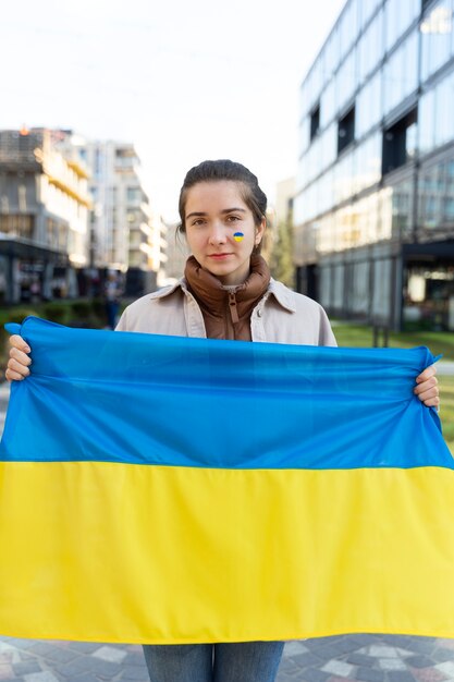 front view woman holding ukrainian flag