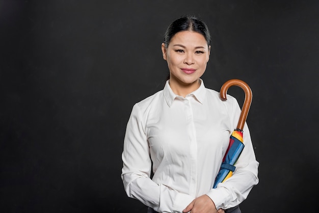 Foto gratuita ombrello della tenuta della donna di vista frontale