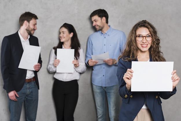 Front view of woman holding up blank paper