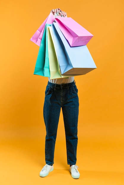 Front view of woman holding up sale shopping bags