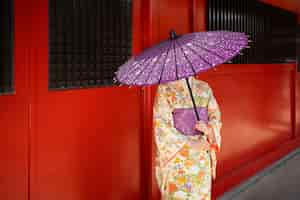 Free photo front view woman holding wagasa umbrella