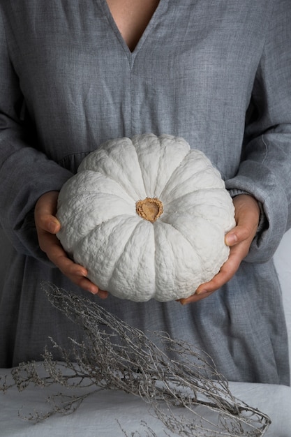 Front view woman holding white pumpkin