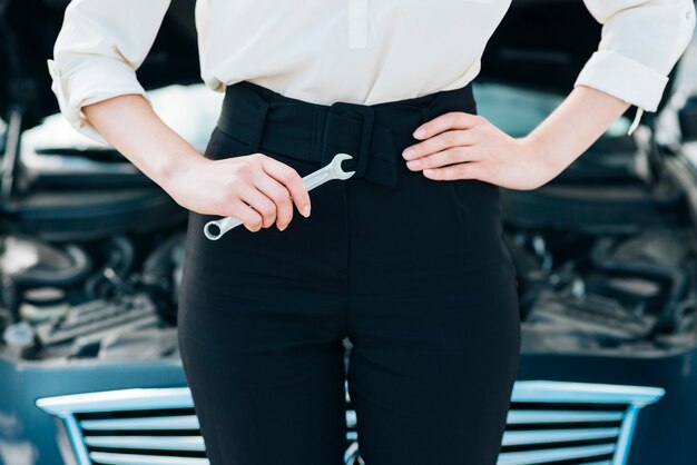 Front view of woman holding wrench