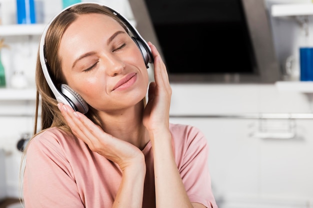 Front view of woman at home listening to music