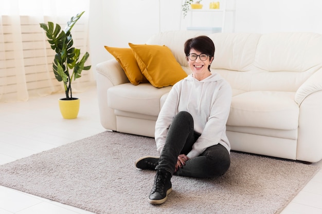 Vista frontale della donna a casa accanto al divano