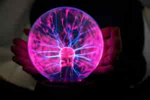 Free photo front view woman interacting with a plasma ball