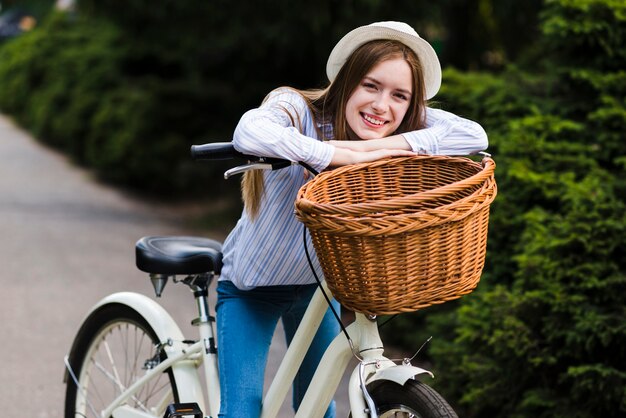 Free photo front view woman leaning against bike handlebar