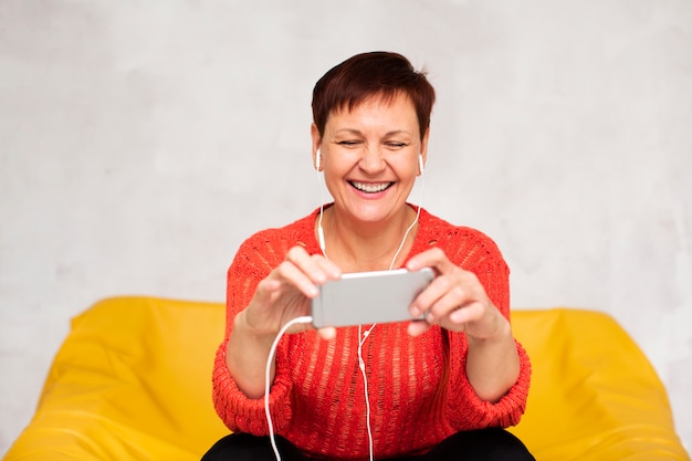 Front view woman listening music and looking on phone