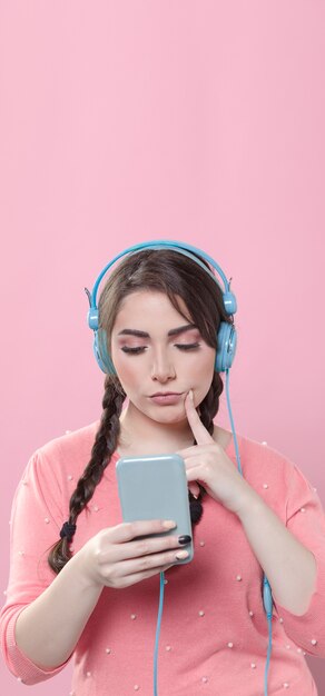 front view of woman listening to music and looking at phone