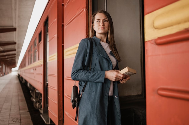 Foto gratuita donna di vista frontale che osserva via mentre entra nel treno