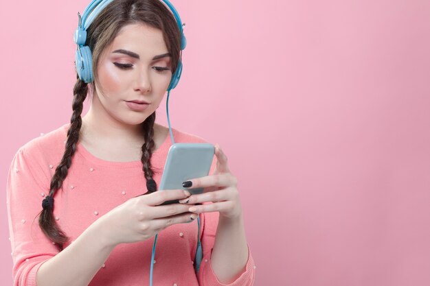 Foto gratuita vista frontale della donna che esamina il suo telefono mentre indossa le cuffie