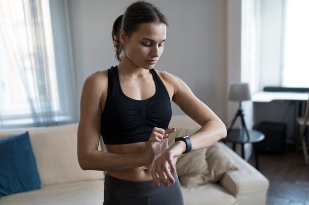 彼女のスマートウォッチを見ている女性の正面図