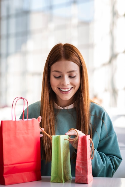 Free photo front view woman looking into shopping bags