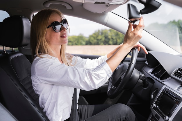 Front view of a woman looking at rearview mirror