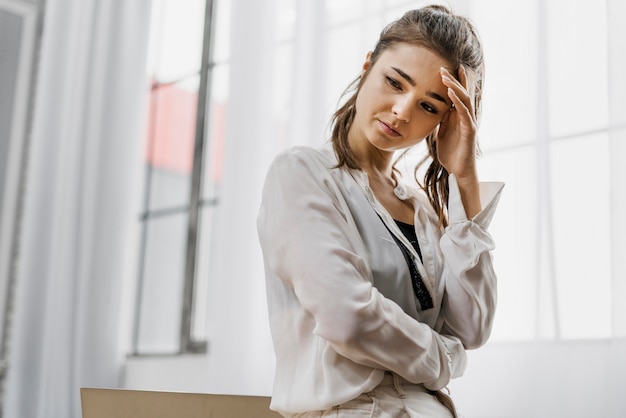 Foto gratuita donna di vista frontale che sembra triste mentre lavorava troppo da casa