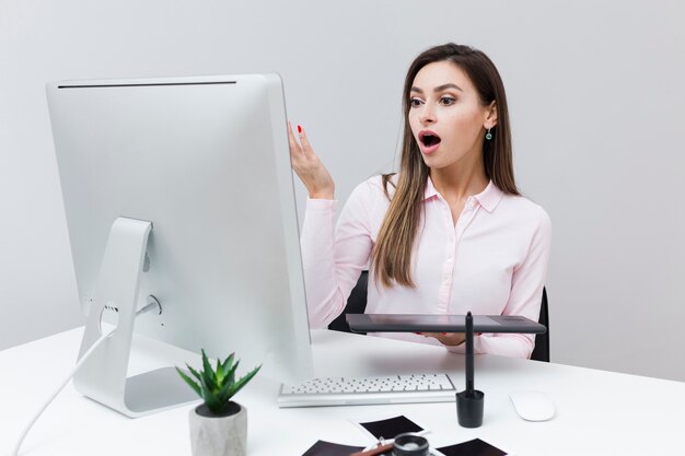 Front view of woman looking surprised at computer screen