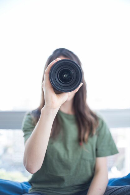 Front view of a woman looking through camera lens