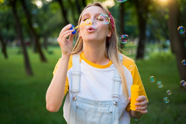 Front view of woman making bubbles outdoors