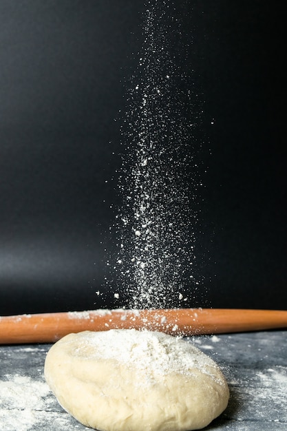 A front view woman making dough with flour on grey desk pastry lady food