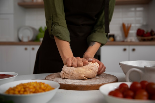 Foto gratuita donna di vista frontale che produce pizza