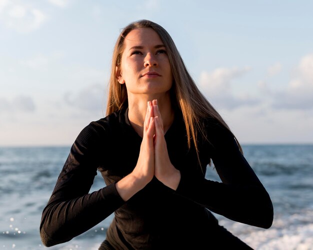 ビーチで瞑想する正面図の女性