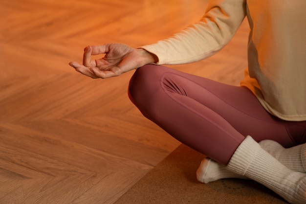 Free photo front view woman meditating on mat