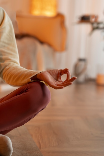 Free photo front view woman meditating on mat