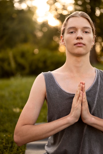 Free photo front view woman meditating outdoors